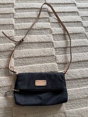 kate spade black crossbody with tan strap and gold logo plate